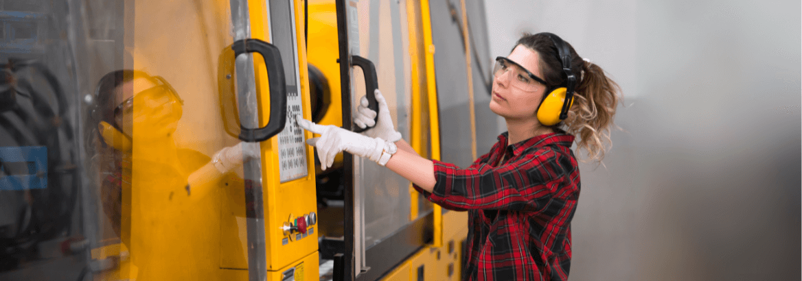 Aufnahme einer Konstrukteurin vor der Schutzeinrichtung einer Maschine