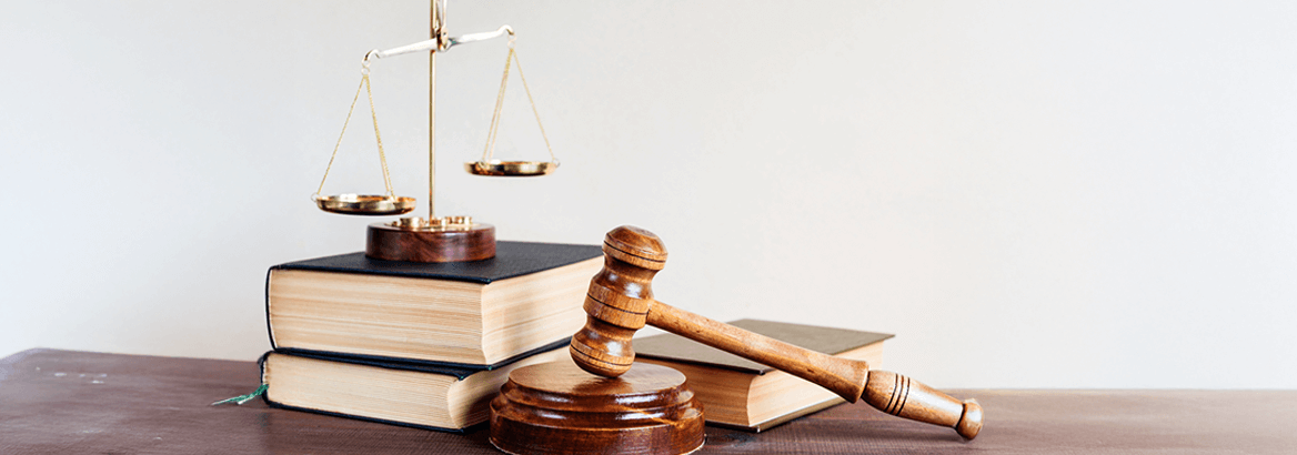 Hammer eines Richters vor einem STapel Bücher