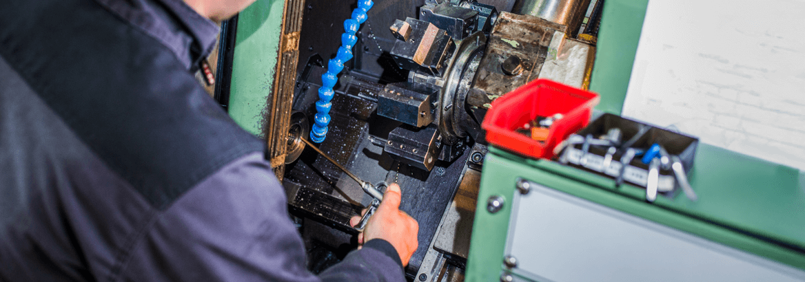Ein Arbeiter manipuliert eine CNC Maschine