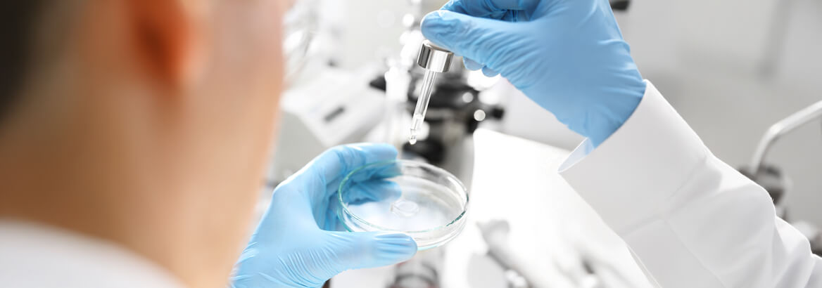 Ein Labortechniker trägt eine Probe auf einen Objektträger auf.